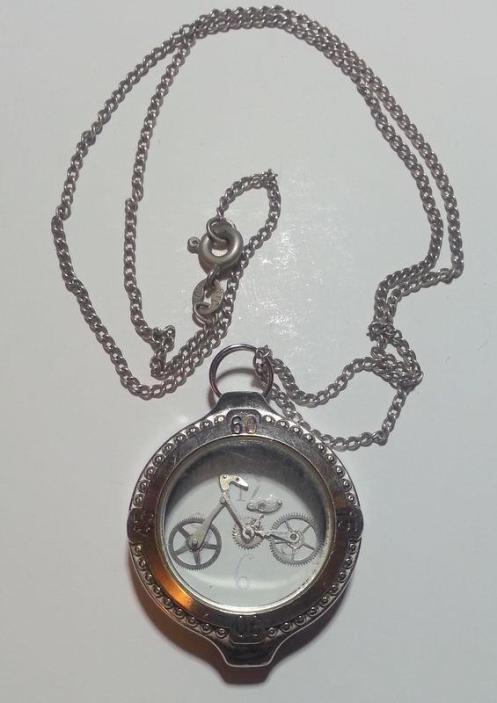 A pendant. Bicycle made of watch parts inside a watch case. 